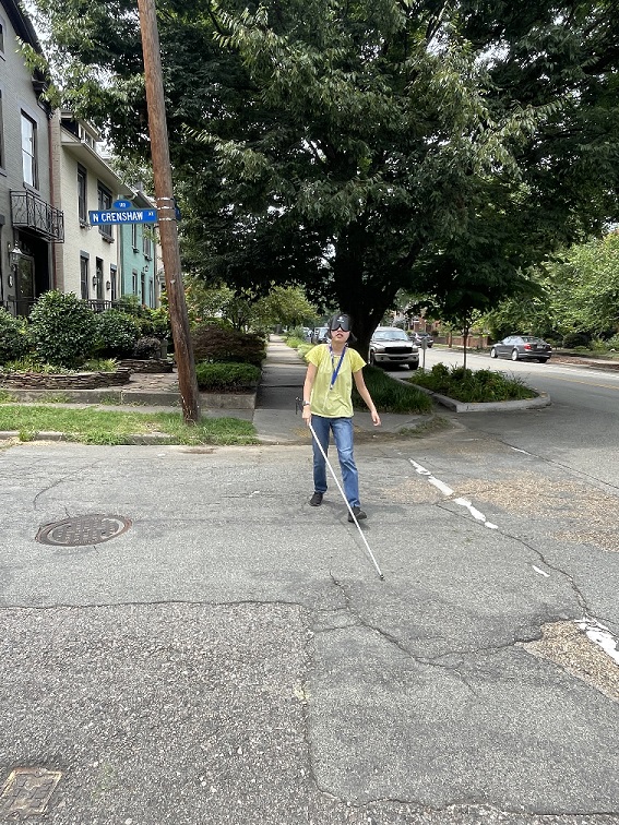 Former LIFE student crosses street with a cane